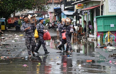 Prajurit TNI AL Pangkalan TNI (Lanal) Denpasar membagikan makanan minuman  kepada warga terdampak banjir besar di kawasan Gelogor Carik, Kota Denpasar, Rabu (10/09/2025
