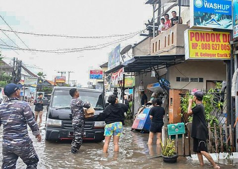 Prajurit TNI AL Pangkalan TNI (Lanal) Denpasar membagikan makanan minuman  kepada warga terdampak banjir besar di kawasan Gelogor Carik, Kota Denpasar, Rabu (10/09/2025