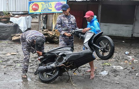 Prajurit TNI AL Pangkalan TNI (Lanal) Denpasar membantu warga yang motornya terendam banjir  di kawasan Gelogor Carik, Kota Denpasar, Rabu (10/09/2025).