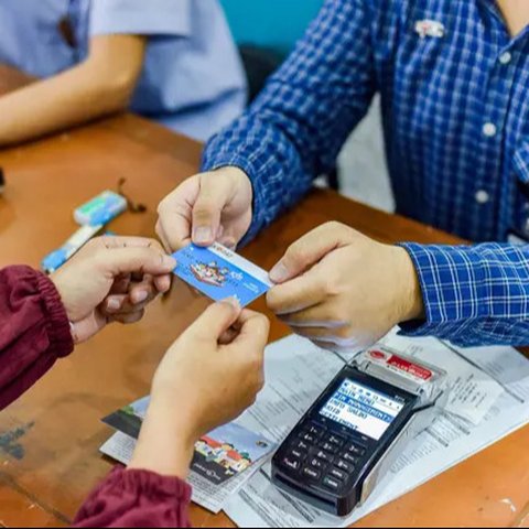 Orangtua dari anak penerima saat menunjukkan KJP yang baru diterima di kawasan Matraman, Jakarta, Selasa (24/11/2020). Penyaluran KJP plus tahap kedua ini menggunakan data baru berdasarkan pe