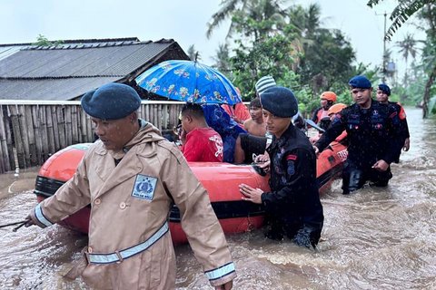 Anggota Brimob Polda Bali mengevakuasi warga saat banjir besar menerjang Pulau Bali, Rabu (10/9/2025)