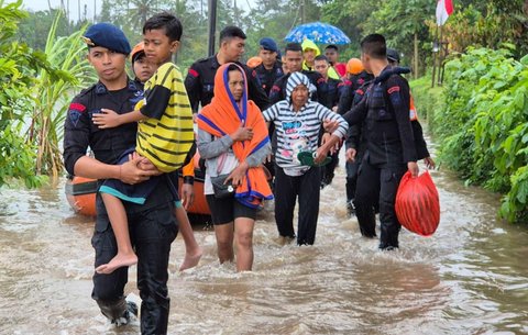 Anggota Brimob Polda Bali mengevakuasi warga saat banjir besar menerjang Pulau Bali, Rabu (10/9/2025)