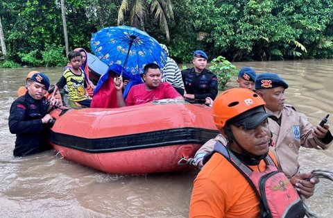 Anggota Brimob Polda Bali mengevakuasi warga saat banjir besar menerjang Pulau Bali, Rabu (10/9/2025)