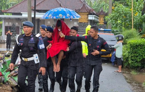 Anggota Brimob Polda Bali mengevakuasi warga saat banjir besar menerjang Pulau Bali, Rabu (10/9/2025)