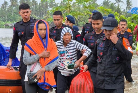 Anggota Brimob Polda Bali mengevakuasi warga saat banjir besar menerjang Pulau Bali, Rabu (10/9/2025)