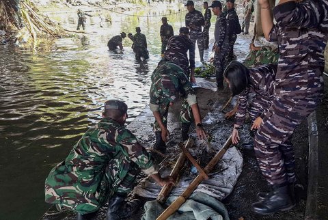 Tim Satgas Bencana Banjir Pangkalan TNI AL (Lanal) Denpasar bersama petugas gabungan dari unsur TNI AD dan kepolisian membersihkan area tergenang lumpur dan dipenuhi sampah sisa banjir di wilayah Pasar Badung, Denpasar, Sabtu (13/09/2026).