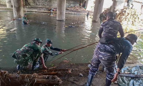 Tim Satgas Bencana Banjir Pangkalan TNI AL (Lanal) Denpasar bersama petugas gabungan dari unsur TNI AD dan kepolisian membersihkan area tergenang lumpur dan dipenuhi sampah sisa banjir di wilayah Pasar Badung, Denpasar, Sabtu (13/09/2026).
