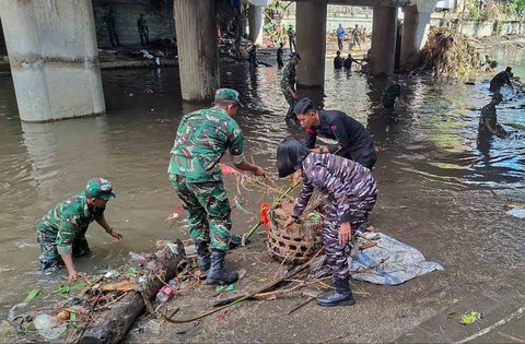 Tim Satgas Bencana Banjir Pangkalan TNI AL (Lanal) Denpasar bersama petugas gabungan dari unsur TNI AD dan kepolisian membersihkan area tergenang lumpur dan dipenuhi sampah sisa banjir di wilayah Pasar Badung, Denpasar, Sabtu (13/09/2026).