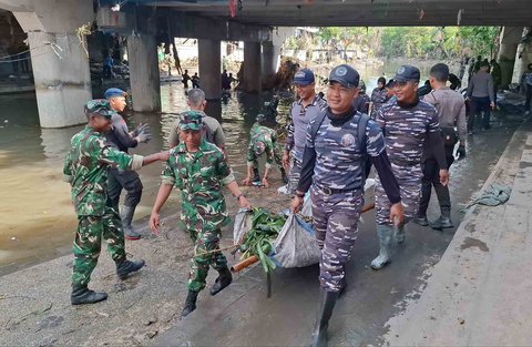 Tim Satgas Bencana Banjir Pangkalan TNI AL (Lanal) Denpasar bersama petugas gabungan dari unsur TNI AD dan kepolisian membersihkan area tergenang lumpur dan dipenuhi sampah sisa banjir di wilayah Pasar Badung, Denpasar, Sabtu (13/09/2026).