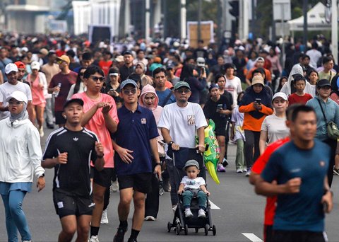 Warga berolahraga dan jalan santai di arena car free day (CFD) Jalan Thamrin, Jakarta, Minggu (14/9/2025).