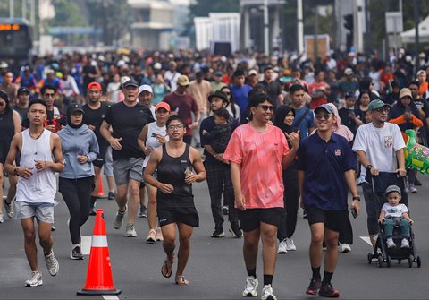 Warga berolahraga dan jalan santai di arena car free day (CFD) Jalan Thamrin, Jakarta, Minggu (14/9/2025).