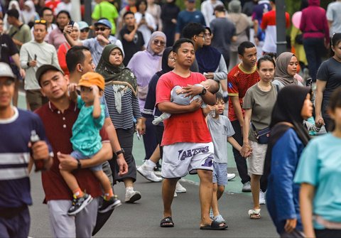 Warga berolahraga dan jalan santai di arena car free day (CFD) Jalan Thamrin, Jakarta, Minggu (14/9/2025).