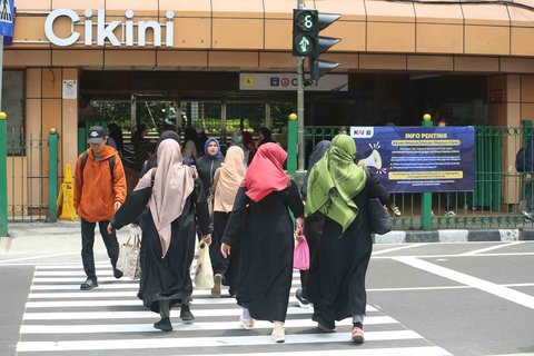 Pejalan kaki melintasi penyeberangan pejalan kaki yang dikontrol lampu lalu lintas atau dikenal sebagai persimpangan pelikan (pelican crossing) di  sisi timur Stasiun Cikini, Jakarta, Senin (15/09/2025).