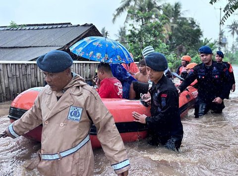Anggota Brimob Polda Bali mengevakuasi warga saat banjir besar menerjang Pulau Bali, Rabu (10/9/2025)