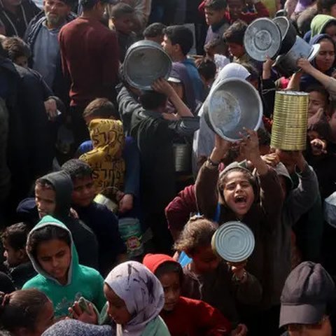 Warga, termasuk anak-anak pengungsi Palestina berkumpul untuk menerima bantuan makanan yang didistribusikan di Deir al-Balah, Jalur Gaza tengah pada 16 Januari 2025. (Eyad BABA/AFP)