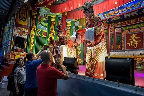 Para penari opera tradisional Tiongkok dari Dongshan, Tiongkok, yang dikenal sebagai wayang orang Tiongkok, menerima persembahan di atas panggung sebelum tampil pada hari pertama pertunjukan untuk komunitas Tionghoa setempat di Vihara Budhi Dharma di Tandem, Sumatera Utara (16/09/2025).