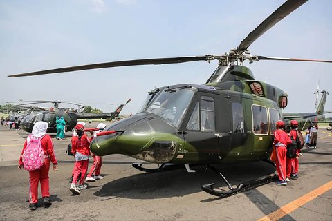 Murid sekolah menyaksikan helikopter TNI AD di Pintu Timur Silang Monas, Jakarta Pusat, Kamis (19/09/2025).