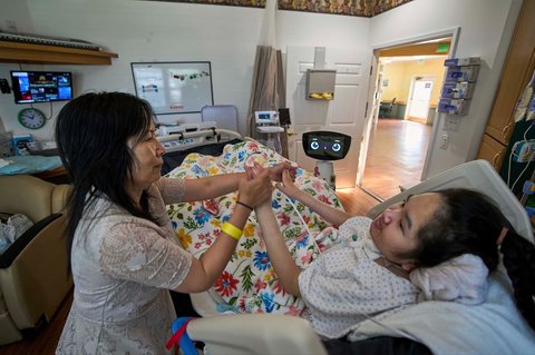 Robot Robin berinteraksi dengan Cara Nguyen bersama putrinya, Kathy, 18 tahun, di Rumah Sakit Spesialis Anak HealthBridge Orange di Orange, California, Jumat (12/9/2025).