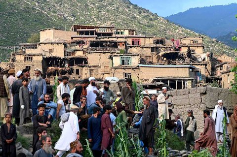 Warga Afghanistan berkumpul di dekat rumah-rumah yang rusak akibat gempa bumi di desa Mazar Dara, distrik Nurgal, provinsi Kunar, Afghanistan Timur, Senin