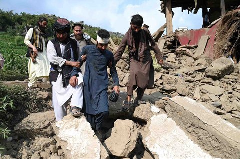 Korban terluka berjalan diantara rumah-rumah yang rusak akibat gempa bumi di desa Mazar Dara, distrik Nurgal, provinsi Kunar, Afghanistan Timur, Senin (01/09/2025).