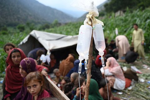 Warga  yang terluka menerima perawatan, dengan infus di latar depan di sebuah lapangan setelah gempa bumi di desa Mazar Dara, Distrik Nurgal, Provinsi Kunar, Afghanistan Timur, Senin (01/09/2025).