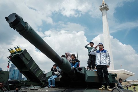 Pengunjung berfoto dengan peralatan militer saat kegiatan  pameran alutsista TNI Fair 2025 di kawasan Monas, Jakarta, Minggu (21/05/2025).