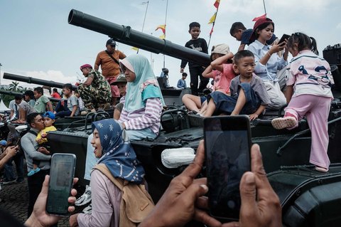 Pengunjung berfoto dengan peralatan militer saat kegiatan  pameran alutsista TNI Fair 2025 di kawasan Monas, Jakarta, Minggu (21/05/2025).