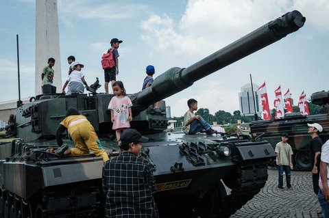 Anak-anak  berfoto dengan peralatan militer saat kegiatan  pameran alutsista TNI Fair 2025 di kawasan Monas, Jakarta, Minggu (21/05/2025).