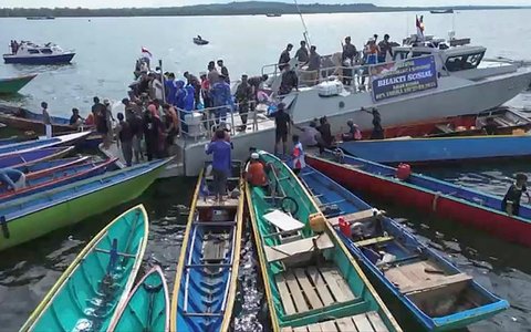 Anggota Satgas Operasi Trisila dan Lanal Balikpapan TNI AL melakukan  bakti sosial pembagian 250 paket sembako kepada nelayan di Perairan Teluk Balikpapan, Jumat (19/09/2025)/