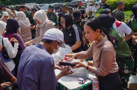 Warga mendapatkan nasi boks gratis yang disediakan  Pusbekangad TNI AD saat pelaksanaan TNI AD Fair 2025 di Monas, Minggu (21/09/2025).