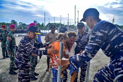 Personil KRI dr. Wahidin Sudirohusodo TNI AL membantu warga menaiki kapal di Dermaga Wanam, Merauke, Papua Selatan, Senin (22/9/2025).