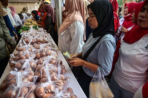 Warga antri  membeli kebutuhan pokok saat kegiatan Gerakan Pangan Murah (GPM)   di Taman 10 Nopember, Tambaksari, Surabaya, Selasa (23/9/2025).