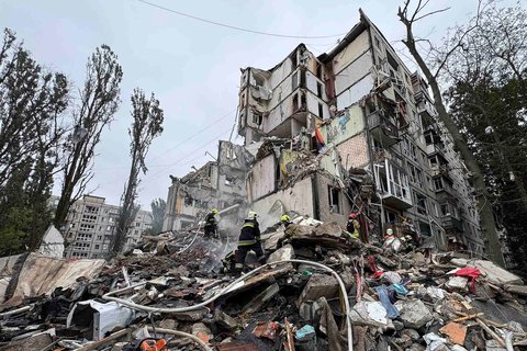Petugas tanggap darurat Ukraina berjibaku di tengah puing-puing bangunan permukiman yang hancur akibat serangan udara Rusia di Kyiv, Kamis (31/07/2025).