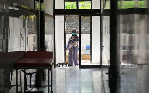 Seorang ibu menggendong putranya di bangsal isolasi pasien campak di Rumah Sakit Moh Anwar, Sumenep, , Madura, Jawa Timur (10/09/ 2025).