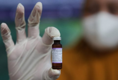 Seorang tenaga kesehatan menunjukkan botol vaksin campak-rubela saat kampanye vaksinasi saat kampanye vaksinasi door-to-door di Sumenep, Madura, Jawa Timur (08/09/ 2025).