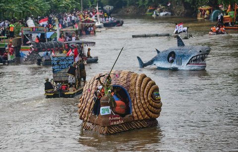 Peserta dengan perahu yang terbuat dari sampah daur ulang mengikuti Festival Perahu Cilung 2025 di Kali Ciliwung, Pancoran, Jakarta Selatan, Minggu (28/09/2025).