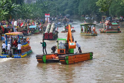 Peserta dengan perahu yang terbuat dari sampah daur ulang mengikuti Festival Perahu Cilung 2025 di Kali Ciliwung, Pancoran, Jakarta Selatan, Minggu (28/09/2025).