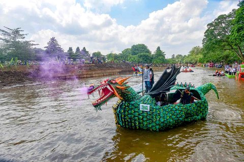 Peserta dengan perahu yang terbuat dari sampah daur ulang mengikuti Festival Perahu Cilung 2025 di Kali Ciliwung, Pancoran, Jakarta Selatan, Minggu (28/09/2025).