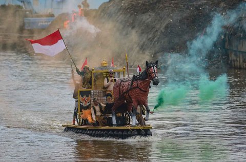 Peserta dengan perahu yang terbuat dari sampah daur ulang mengikuti Festival Perahu Cilung 2025 di Kali Ciliwung, Pancoran, Jakarta Selatan, Minggu (28/09/2025).