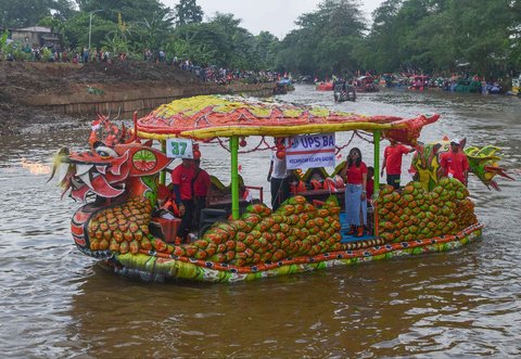 Peserta dengan perahu yang terbuat dari sampah daur ulang mengikuti Festival Perahu Cilung 2025 di Kali Ciliwung, Pancoran, Jakarta Selatan, Minggu (28/09/2025).