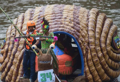 Peserta dengan perahu yang terbuat dari sampah daur ulang mengikuti Festival Perahu Cilung 2025 di Kali Ciliwung, Pancoran, Jakarta Selatan, Minggu (28/09/2025).