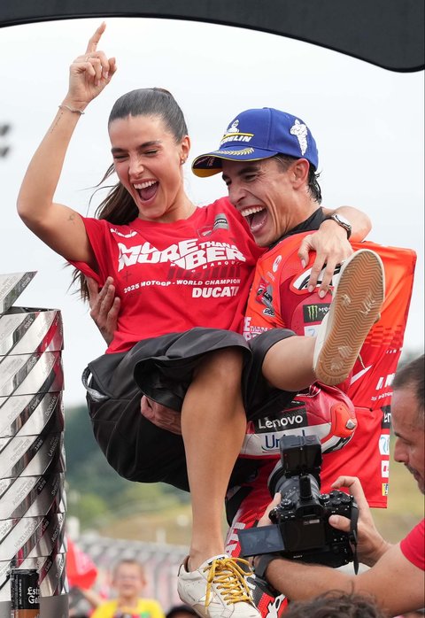 Pembalap Spanyol Marc Marquez dari Tim Ducati Lenovo merayakan kemenangannya bersama kekasihnya, Gemma Pinto, setelah meraih gelar juara MotoGP ketujuh dan gelar juara dunia kesembilannya di Grand Prix MotoGP Jepang di Sirkuit Motegi, Motegi, utara Tokyo, Minggu (28/09/2025).