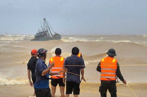 Warga saat menyelamatkan nelayan di kapal nelayan yang terdampar akibat Topan Bualoi di Quang Tri, Vietnam, Minggu (26/09/2025).