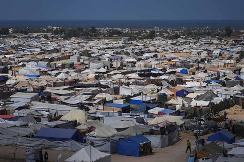 Warga Palestina yang terlantar berjalan melewati kamp tenda di Muwasi, wilayah yang ditetapkan Israel sebagai zona aman, di Khan Younis, Jalur Gaza selatan, Senin (29/09/2025).