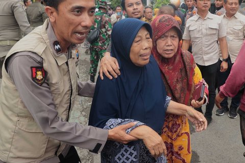 Kelurga korban menangis di kompleks pesantren  Al Khoziny di Sidoarjo, Jawa Timur, Selasa (30/09/2025).