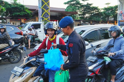 Anggota Polri membagikan paket sembako di perempatan depan Mabes Polri, Jalan Trunojoyo, Jakarta, Kamis sore (05/09/2025).