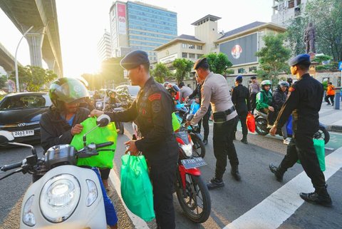 Anggota Polri membagikan paket sembako di perempatan depan Mabes Polri, Jalan Trunojoyo, Jakarta, Kamis sore (05/09/2025).