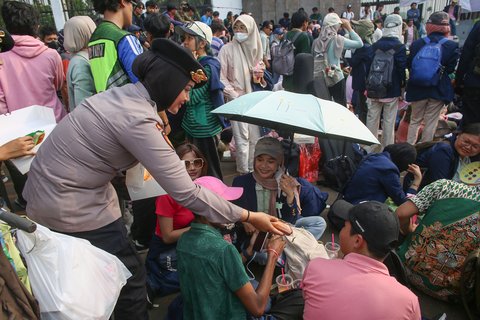 Polwan membagikan roti saat mahasiswa mengatasnamakan Koalisi Masyrakat Sipil  menggelar aksi bertema 'Piknik Nasional Rakyat' di depan Gedung DPR RI, Senayan, Jakarta Pusat, Jumat (5/9/2025).