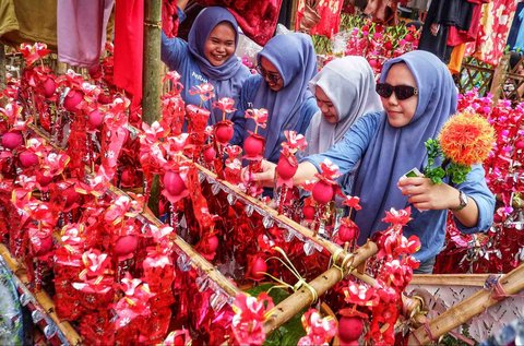 Warga mempersiapkan makanan yang akan dibagikan di atas  miniatur perahu Pinisi di Desa Damai, Sulawesi Selatan, Minggu (07/09/2025).