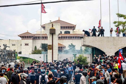 Para demonstran yang membawa bendera nasional Nepal menggelar protes di luar Gedung Parlemen di Kathmandu, Nepal,  Senin (08/09/2025).